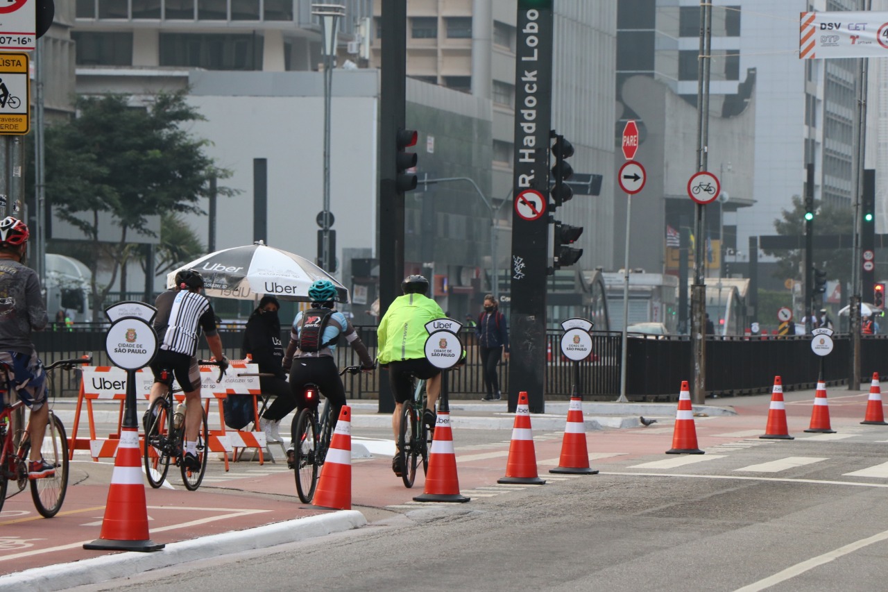 Foto de ciclistas de costas, pedalando na ciclofaixa de lazer